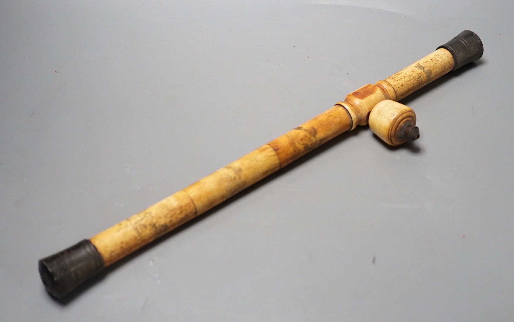 A Chinese bone opium pipe with figural decoration, 46cm wide